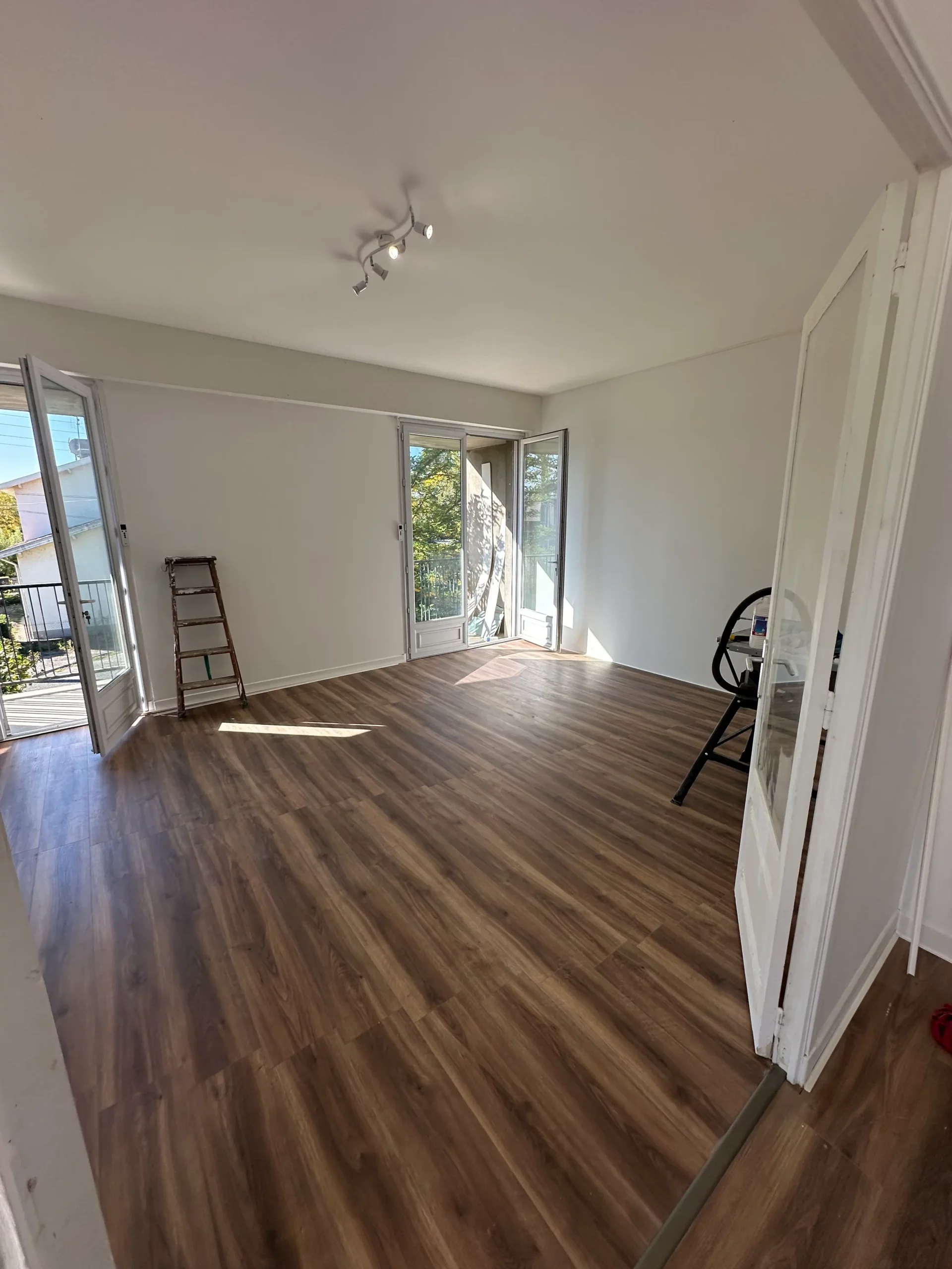 Pièce rénovée lumineuse avec parquet et baies vitrées, aménagement intérieur mgb-services à Castres